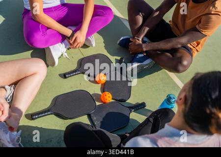 Gruppi di amici diversi seduti su un campo da baseball Foto Stock