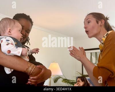 Una coppia interrazziale tiene il bambino durante una festa per la baby shower a Pittsburgh, Pennsylvania Foto Stock