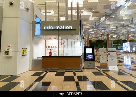 Singapore - 9 dicembre 2025: Un banco informazioni nella sala partenze dell'Aeroporto Internazionale Changi Terminal 3. Foto Stock