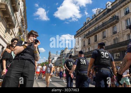Il CRS è in una dimostrazione parigina, una donna scatta foto Foto Stock