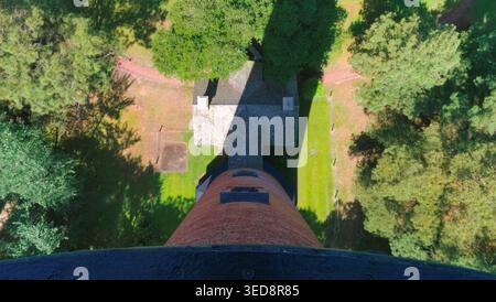 Vista verso il basso dalla cima del faro di Currituck Beach con vista sulla struttura del faro e sul paesaggio circostante a Corolla, North Carolina, Stati Uniti Foto Stock