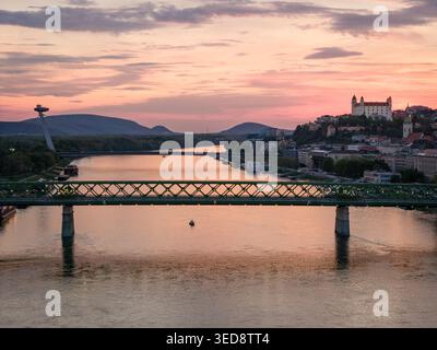 BRATISLAVA, SLOVACCHIA - 19 APRILE 2026: Splendida vista del tramonto sul Danubio, con il Ponte Vecchio verde (Stary Most) in primo piano Foto Stock