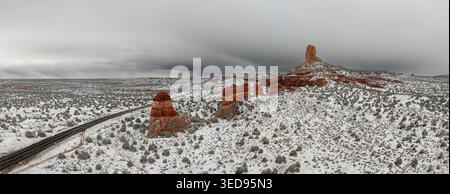 Veduta aerea delle rocce rosse e di una strada tortuosa in un paesaggio desertico innevato sotto nuvole buie e tempestose Page, Arizona, Stati Uniti. Foto Stock