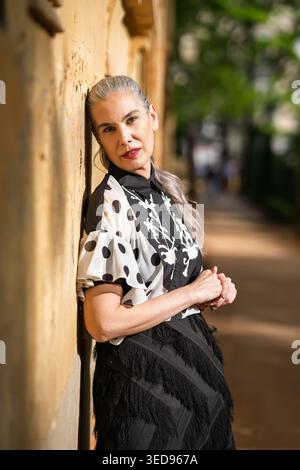 Scena urbana con donna premurosa. Ritratto di una donna alla moda sullo sfondo panoramico Foto Stock