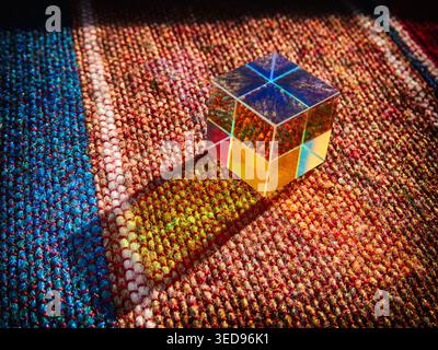 Cubo arcobaleno di vetro su una coperta, simboli e oggetti Foto Stock