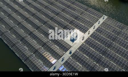 Vista aerea di una grande fattoria solare galleggiante con file di pannelli fotovoltaici che riflettono la luce del sole su un calmo corpo d'acqua a Zwolle, Overijssel, Netherl Foto Stock