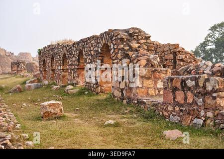 Antiche rovine in pietra di una fortezza storica con muri erosi e porte e finestre ad arco. La struttura è costruita con irregolare Foto Stock
