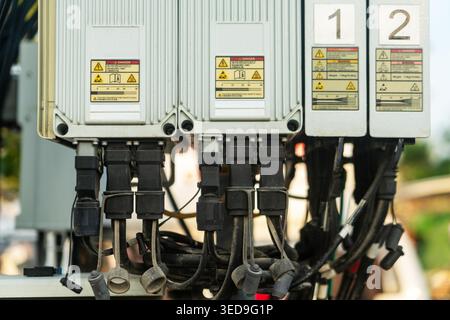 Vista ravvicinata di una scatola di comando elettrica con segnali di avvertimento e vari collegamenti dei fili, che evidenziano la sicurezza e la tecnologia nell'applicazione industriale Foto Stock