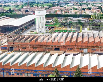 Vista aerea del complesso industriale con la sua iconica torre di acqua bianca e i tetti della fabbrica di seghe a Dalmine, Lombardia, Italia. Foto Stock