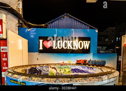 15 aprile 2026 Lucknow India. Diorama ferroviario in miniatura al coperto con binari curvi, rocce, modelli di treni e grande lettura di insegne illuminate i Love luc Foto Stock