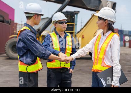 Diversi operatori marittimi asiatici di medie dimensioni si accatastano in una dimostrazione di collaborazione e unità in un cantiere logistico tailandese per la cooperazione commerciale e il lavoro Foto Stock