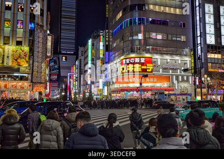 Persone in attesa di attraversare la strada all'attraversamento pedonale nel quartiere Kabukicho di notte. Shinjuku City, Tokyo, Giappone. Foto Stock