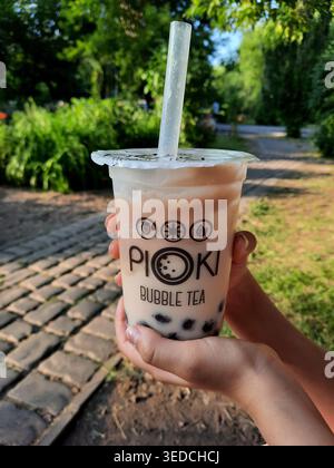 Petropavlovsk, Kazakistan - 11 giugno 2025. Tè dolce al latte con perle di tapioca in una tazza in mano. Foto Stock