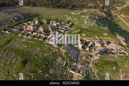Vista aerea con drone della città antica di Hierapolis e dei travertini di Pamukkale a Denizli, Turchia, teatro romano, colonne antiche e paesaggio UNESCO Foto Stock