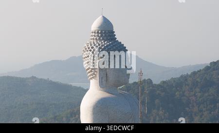 Vista aerea della maestosa statua del grande Buddha in profilo, sullo sfondo di lussureggianti colline verdi e di un cielo nebuloso a Tambon Karon, Chang Wat Phuket, Thai Foto Stock