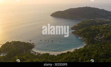 Vista aerea di Hidden Beach con acque turchesi e piccole barche ancorate nella baia durante l'ora d'oro a Rawai, Phuket, Thailandia. Foto Stock