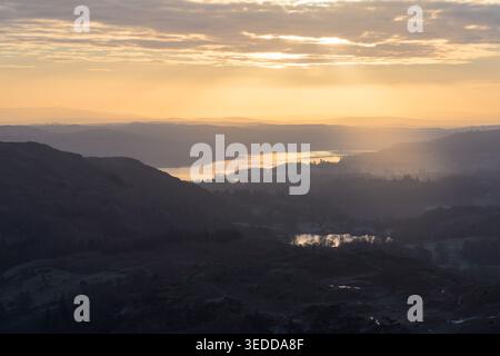 Luce dorata del mattino che attraversa le nuvole su Windermere nel Lake District, Regno Unito. Foto Stock