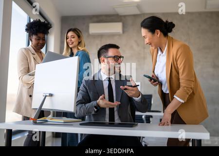 Startup diversificate, persone aziendali che lavorano insieme su un computer portatile in un ufficio moderno Foto Stock