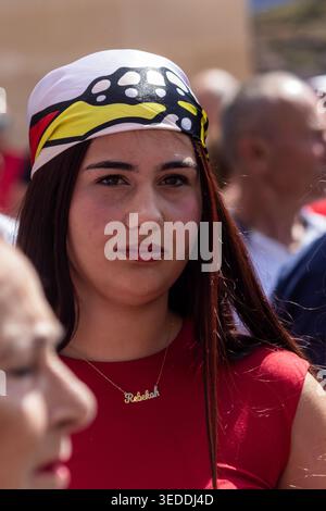 Naxxar, Malta - 3 maggio 2006, Young Woman Portrait wearing Colorful Bandana in Crowded Outdoor Festival Scene Foto Stock