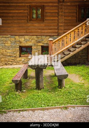Semplice area salotto rustica con panche e tavolo in legno Foto Stock