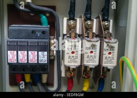 Vista dettagliata dei componenti dei circuiti elettrici all'interno di un quadro strumenti, con interruttori, interruttori e cablaggio per la distribuzione dell'energia e la sicurezza Foto Stock