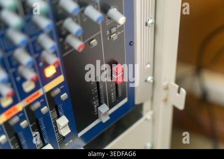 Vista ravvicinata dettagliata di una console di missaggio audio professionale, con manopole e cursori essenziali per il controllo audio in ambienti studio. Ideale Foto Stock
