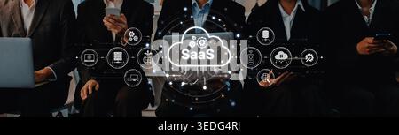 I professionisti aziendali interagiscono attivamente con i loro dispositivi, esplorando le soluzioni software as a Service in uno spazio di lavoro contemporaneo, dimostrando Foto Stock