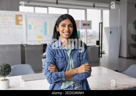Ritratto di un dipendente in ufficio che posa da solo in un ambiente di lavoro moderno Foto Stock