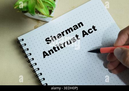 Concetto di Sherman antitrust Act scrivere su libro isolato su Wooden Table Foto Stock