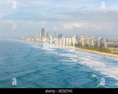 Un'ampia vista aerea del vibrante skyline della Gold Coast, caratterizzato da torreggianti grattacieli costieri che si affacciano sulle onde turchesi e sulle spiagge sabbiose durin Foto Stock