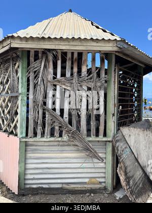 n vecchio gazebo in legno con foglie di palma essiccate sul tetto che si affaccia sulla costa. Foto Stock