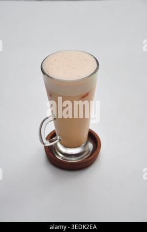 in stile kopitiam, il tarik è servito in un alto bicchiere sopra un tavolo bianco Foto Stock