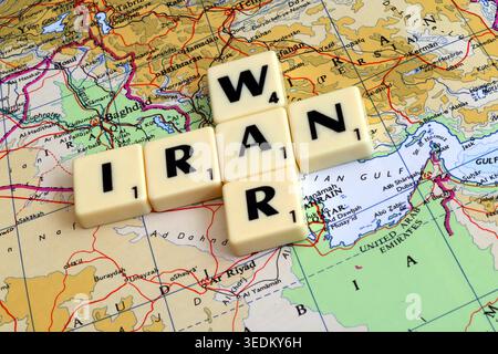 Piastrelle di Scrabble che scrivono Iran e guerra su una mappa del Medio Oriente, un'immagine concettuale per gli shock del prezzo del petrolio, l'inflazione e il rischio geopolitico. Foto Stock