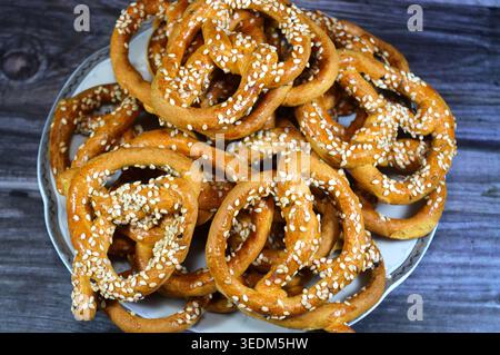 pretzel di sesamo, anelli dorati con borchie di sesamo, uno spuntino croccante, questi più sottili, i pretzel cotti al forno sono pregiati per la loro consistenza croccante, simile a quella di un biscotto, e sono ricoperti Foto Stock