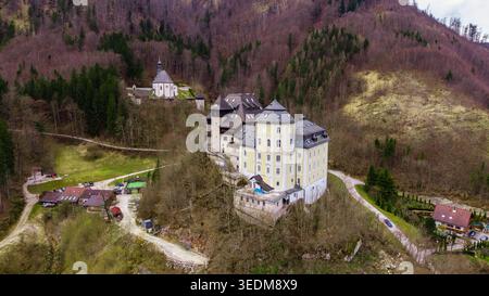 Vista aerea del Castello di Klaus e di una cappella in collina circondata da una fitta foresta di montagna a Klaus an der Pyhrnbahn, alta Austria, Austria. Foto Stock