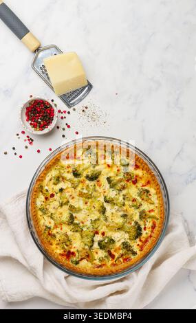 Quiche Lorraine con pollo e broccoli su sfondo di marmo. Torta con verdure, pollame, formaggio, prezzemolo e spezie. Cucina tradizionale francese. SEL Foto Stock