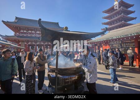I visitatori eseguono la purificazione rituale con fumo di incenso al tempio senso-ji, un antico tempio buddista ad Asakusa, Tokyo, Giappone. Foto Stock