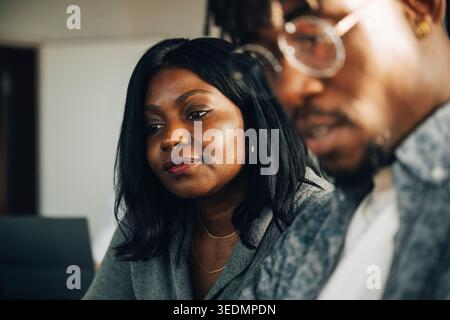 Imprenditrice donna che lavora con un collega maschio presso un moderno ufficio di startup Foto Stock