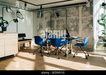 Interni moderni con sedie blu e tavolo da riunione in vetro Foto Stock