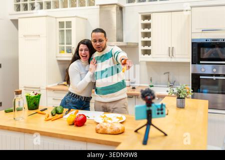 Coppia cucinare cibo sano e registrare un vlog live Foto Stock