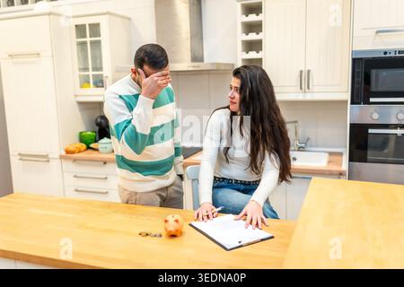 Coppia che deve affrontare lo stress finanziario calcolando la spesa di bilancio in crisi Foto Stock