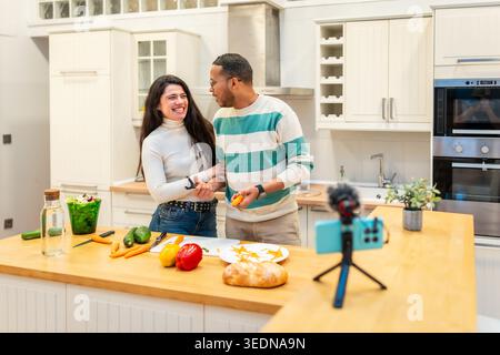 Coppia vlogging cucinare pasto sano per contenuti online Foto Stock