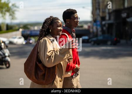 Positive coppie afroamericane, amici maschi e femmine, durante una passeggiata giornaliera in centro città insieme. Foto Stock