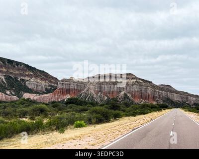 Vista spettacolare delle formazioni rocciose a strati rosse e multicolori, caratterizzate da forme geologiche spettacolari, modelli sedimentari e vegetazione naturale. Foto Stock