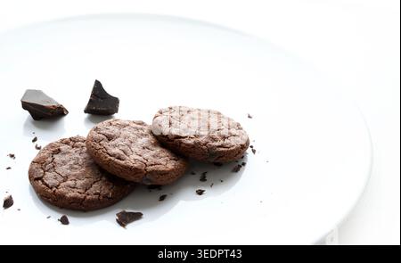 Biscotti con scaglie di cioccolato fondente con briciole isolate su sfondo bianco. Foto di scorta commerciale per lo styling alimentare. Foto Stock