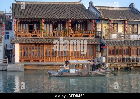 Barche tradizionali e antichi edifici architettonici cinesi lungo un canale d'acqua nel villaggio di Zhujiajiao, Cina Foto Stock
