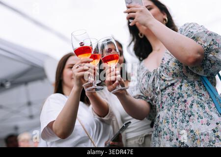 Al Festival del vino di Yerevan i visitatori alzano i bicchieri di vino rosato mentre un partecipante scatta una foto al festival il 7,2024 giugno a Yerevan, in Armenia Foto Stock