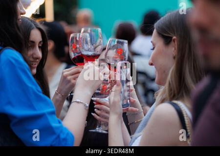 A Yerevan Wine Days i visitatori hanno bicchieri di vino rosso mentre un partecipante fotografa il momento con uno smartphone durante il festival a Yerevan. Foto Stock
