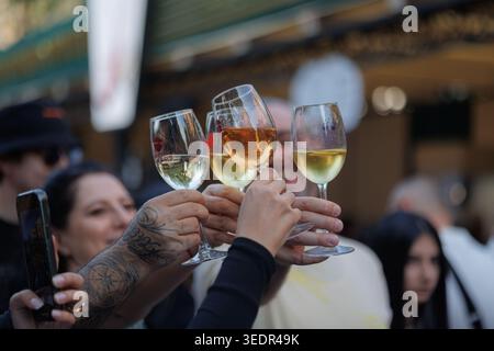 Al Festival del vino di Yerevan, i visitatori alzano quattro bicchieri di vino bianco e rosato in un brindisi mentre scattano foto il 6 giugno 2025 a Yerevan, Armenia. Foto Stock