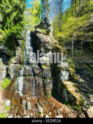 Vista delle cascate su rocce coperte di muschio e scogliere, incorniciate da una foresta lussureggiante, Polana, regione di Banska Bystrica Foto Stock